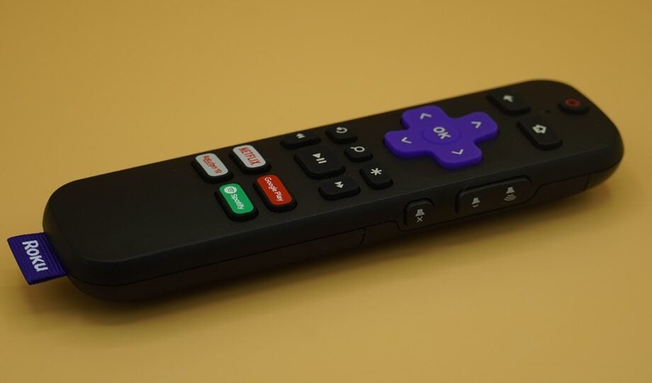 Roku Streambar's black remote resting on a yellow table