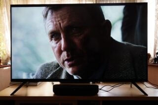 Wide smart screen TV displaying a movie scene with a curious and angry man