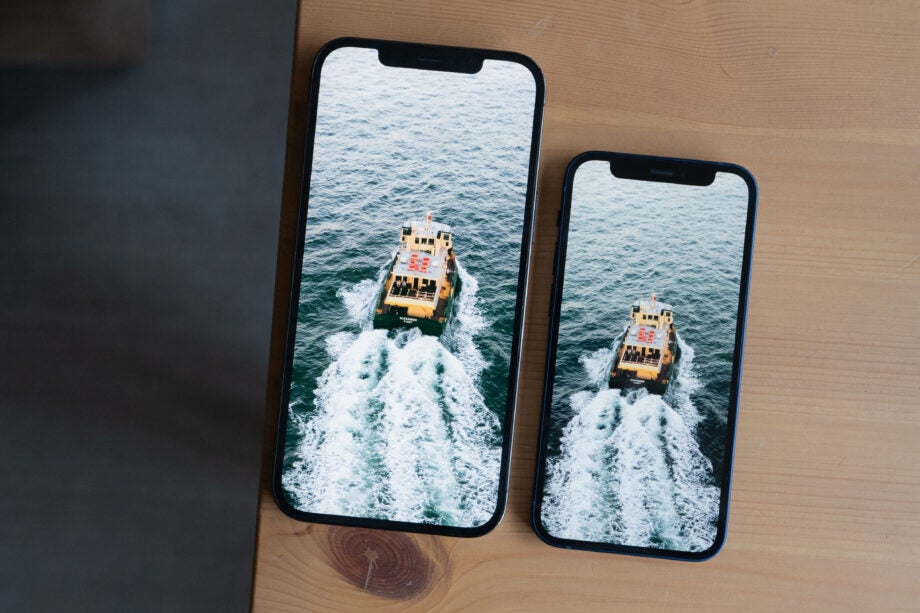 Two iPhones laid on a table aligned vertically, view from top, both displaying an image of a boat in water