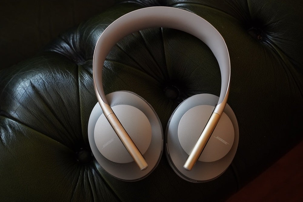 cream color bose headsets resting on soft black couch 