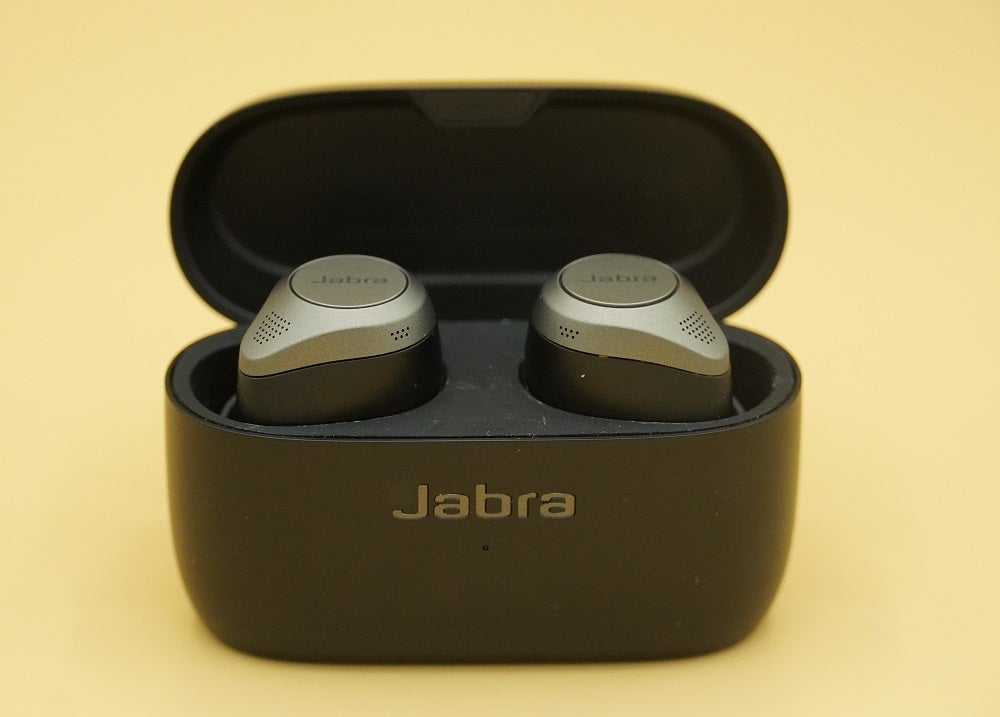 Jabra Elite 85tA black Jabra Elite 85T earbud's case standing on yellow background