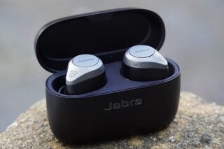Black-silver Jabra Elite 85T earbud's resting in it's black case