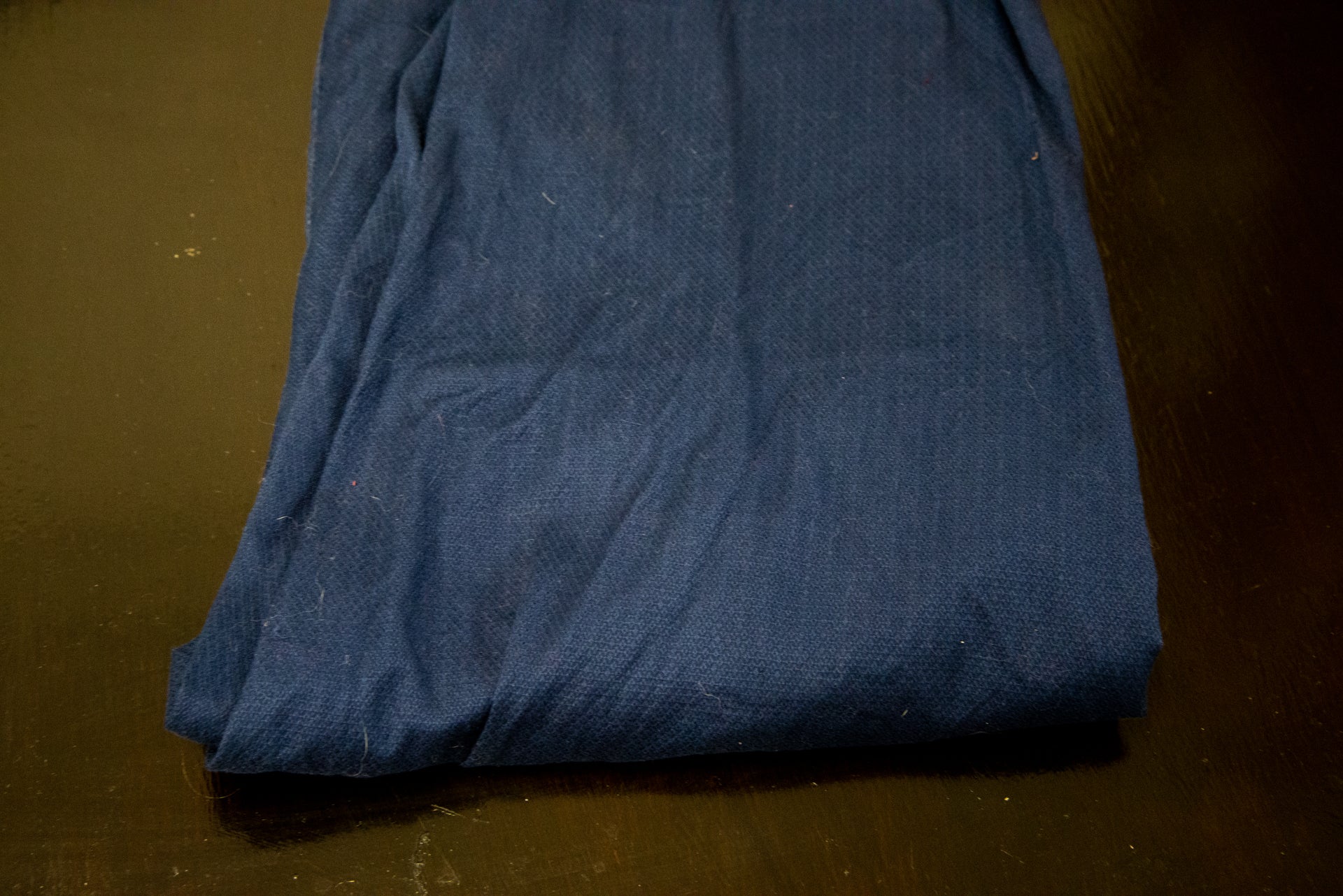 A blue cloth kept on a wooden tableA blue cloth kept on a wooden table