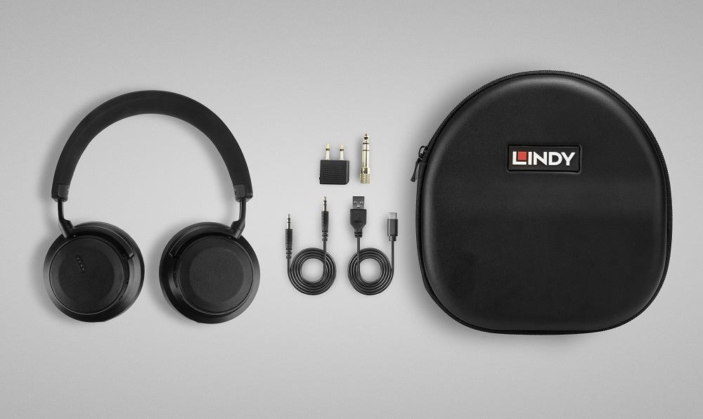 Black Lindy headphones resting on white background with its necessary connection cables and it's case resting beside