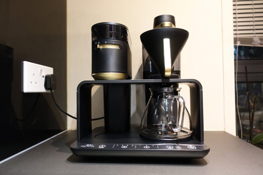 A black-golden Melitta Epos 11 coffe machine plugged in