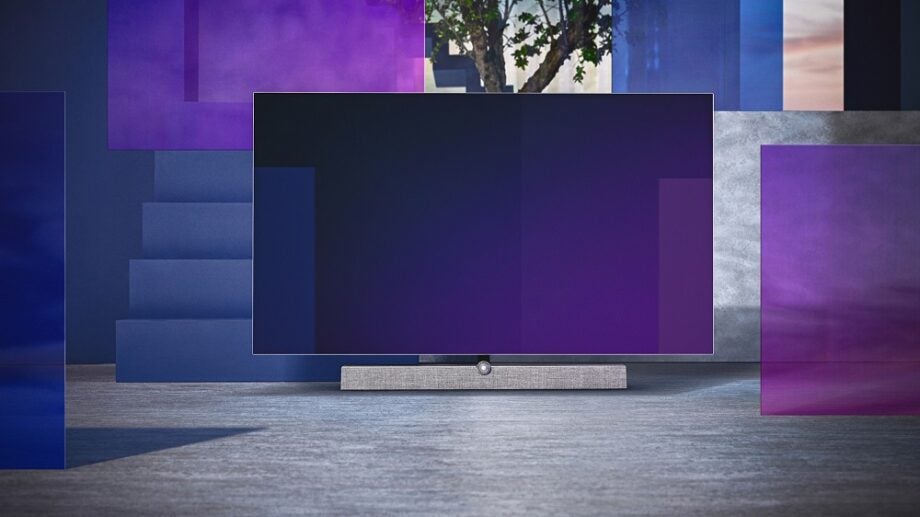 A black and silver Philips OLED 935 standing on a blue-silver background