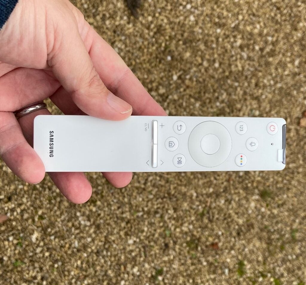 A white Samsung remote held in hand