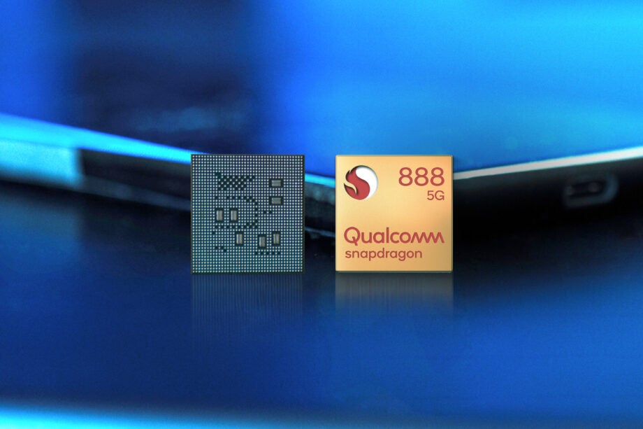 Qualcomm Snapdragon 888 chip and it's cover standing against a laptop