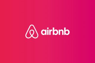 Airbnb logo, airbnb with its logo written on the center on a complete pink background