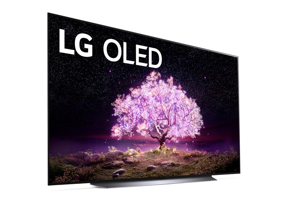 Left andgled view of a silver/gray LG OLED 83 C1 TV standing on white background