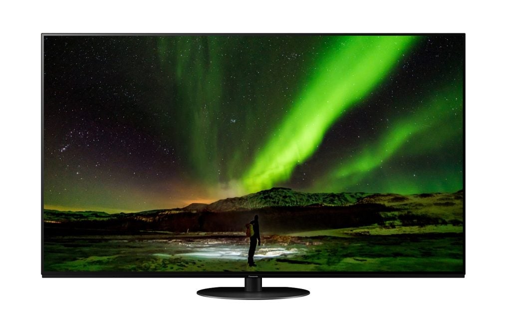 A black Panasonic JZ1500 TV standing on a white background displaying a man standing under the green sky