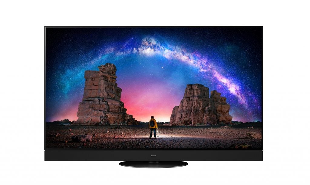 A black Panasonic TX-55JZ2000E TV standing on a white background displaying a man standing in the night sky