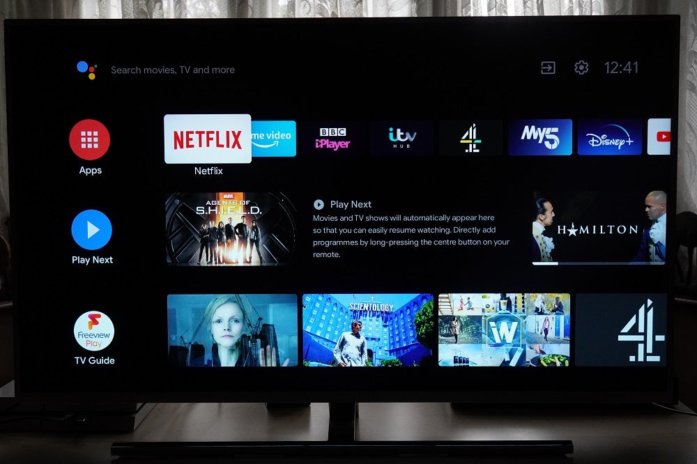 A black Philips 50PUS8545 TV standing on table, displaying Android TV's homescreen