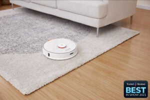A white Roborock S7 vaccum cleaner placed on a white carpet