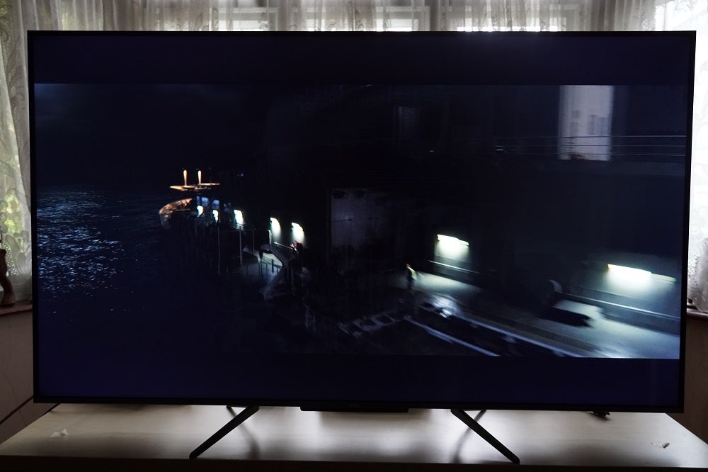 A black TCL-55C715K TV standing on a table, displaying a scene from Captain America