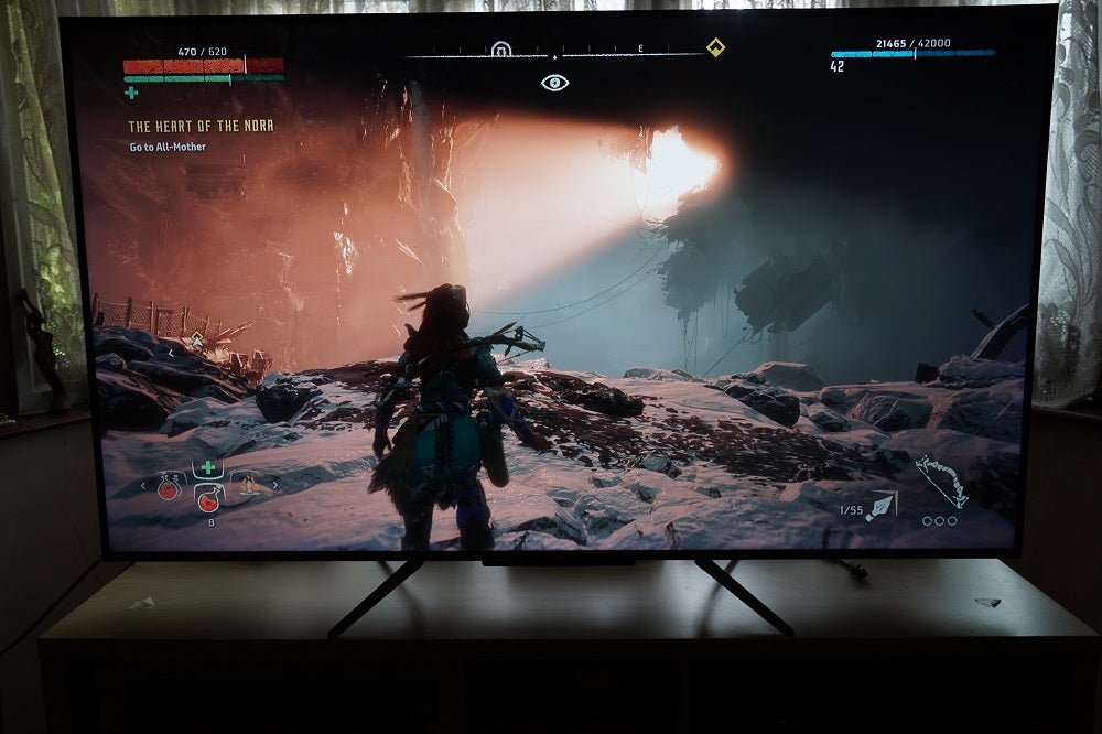 Horizon Zero Dawn on TCL C715A black TCL-55C715K TV standing on a table, displaying System menu over a video