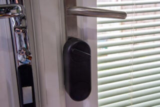 A black Yale linus smart door lock properly fitted on the door