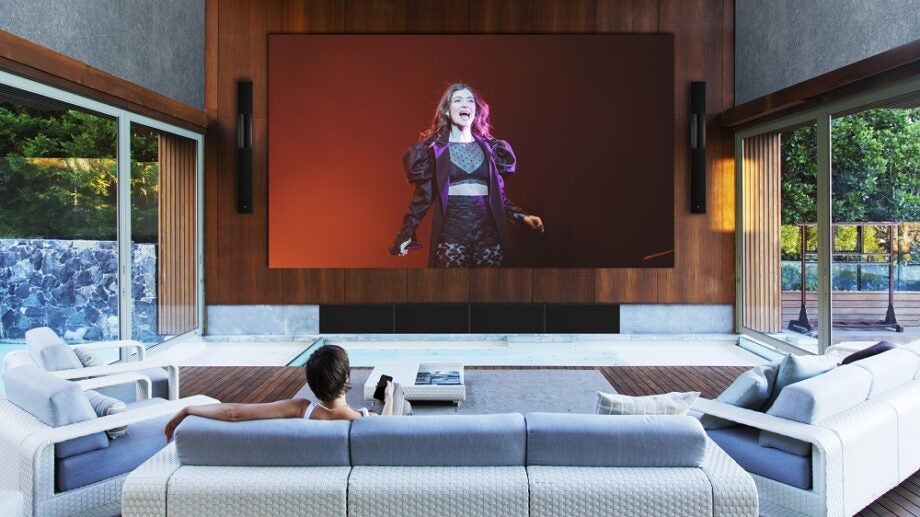 L Acoustics Creations Archipel Lorde sound sytems hangin beside a screen in a living room