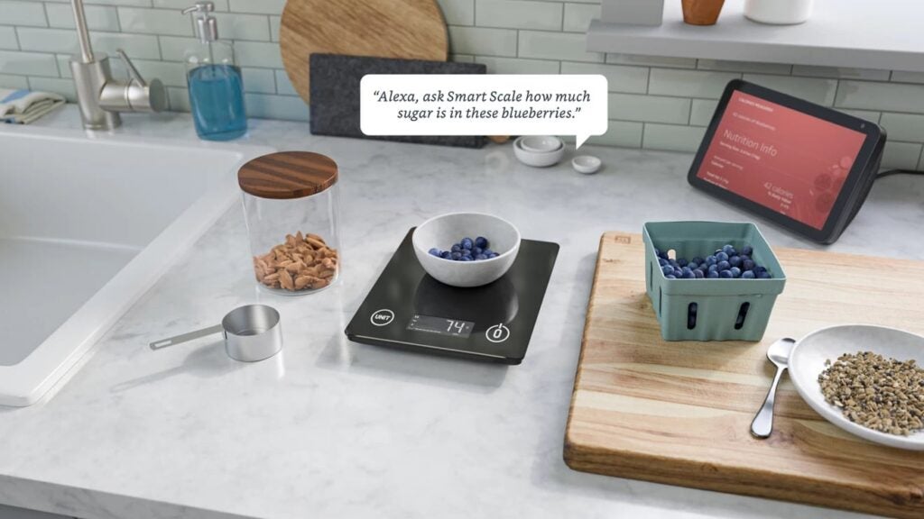 kitchen table besides the sink with grains and fruits on it, placed on smart scale providing  nutrition information