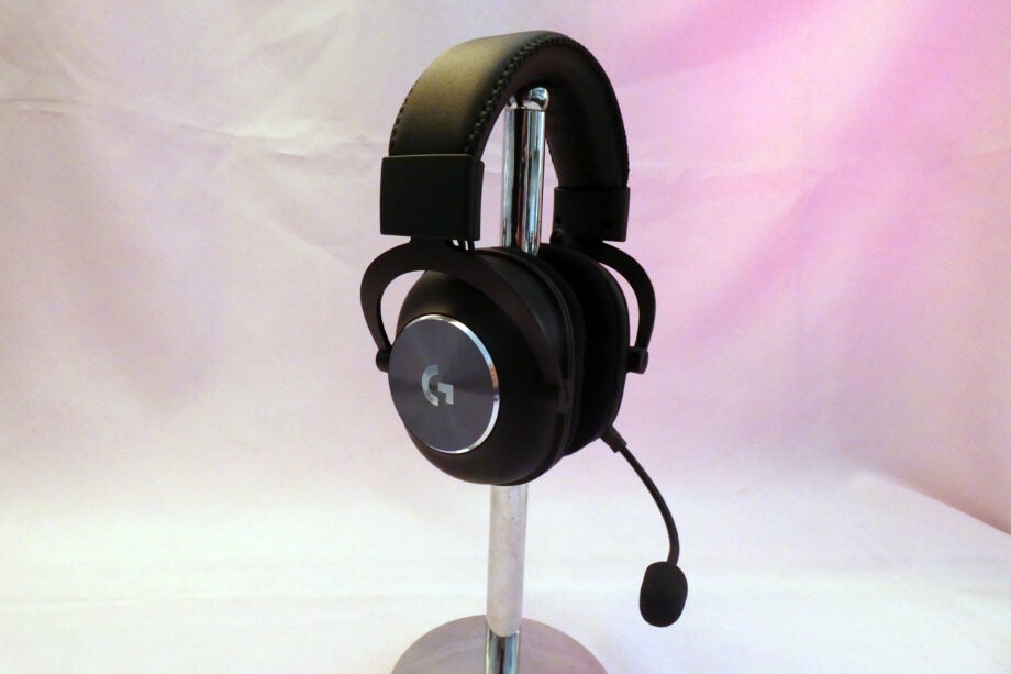 Side view of a black G-Pro X wireless headphone places on a stand
