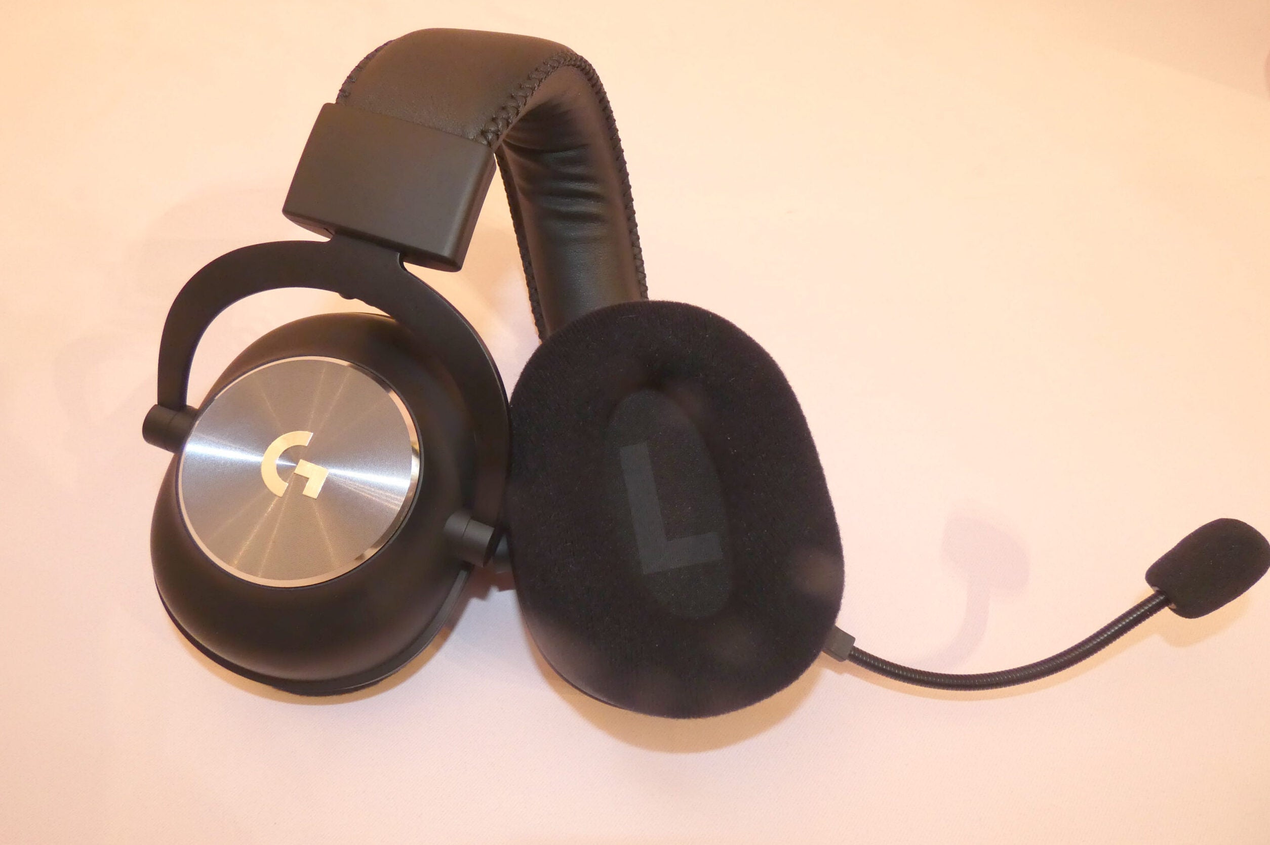 The headset's headband is a little too stiff, making it difficult to unclasp from your head Left and right earpad's view of a black G-Pro X wireless headphone, showing both front and back panels of an earpad