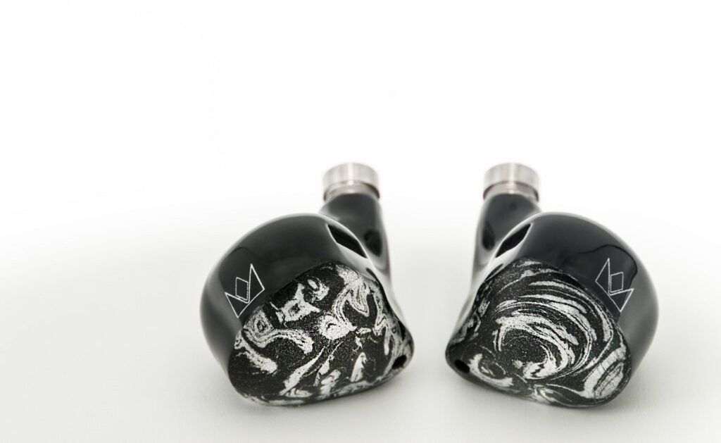 Noble Khan 6-driver Hybrid Universal IEMBlack and white Noble Khan earbuds resting on white background