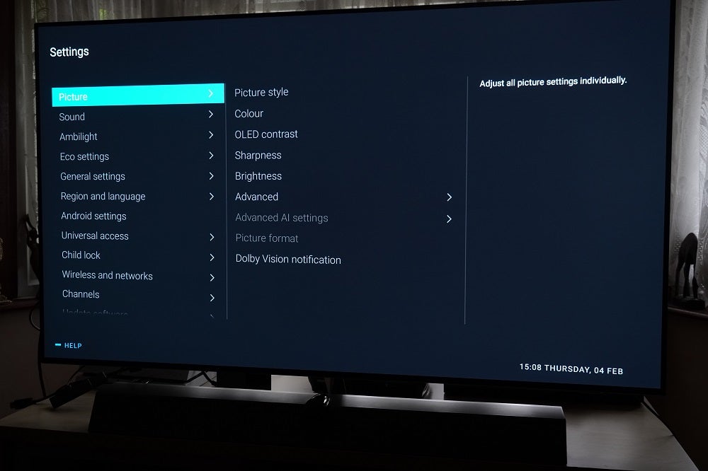 A black Philips OLED935 standing on a table, displaying setting menu with multiple settings