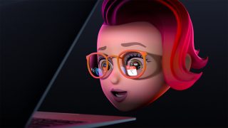 A girl's head wearing specs looking at a laptop