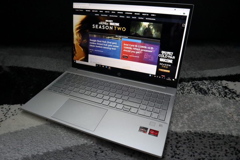 Front right view of a silver HP Pavillion 15 laptop displaying articles from Trusted reviews