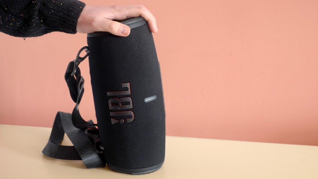 The black Jbl wireless sound speaker with a comfortable soft feel on the hand in vertical position