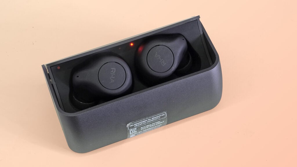 RHA TrueControl ANC inside the charging boxBlack RHA earbuds resting in its gray case, view from top