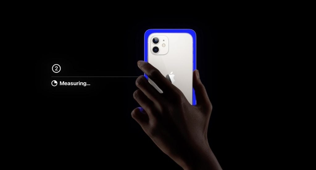 A blue white iPhone held in hand on a black background, showcasing color balance of Apple TV