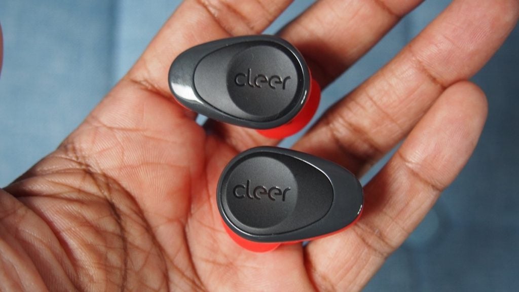 Black and red Cleer Goal earbuds in hand, back view