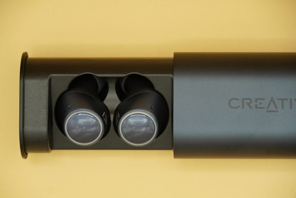 Close up image of black Creative Outlier Air V2 earbuds resting in it's case