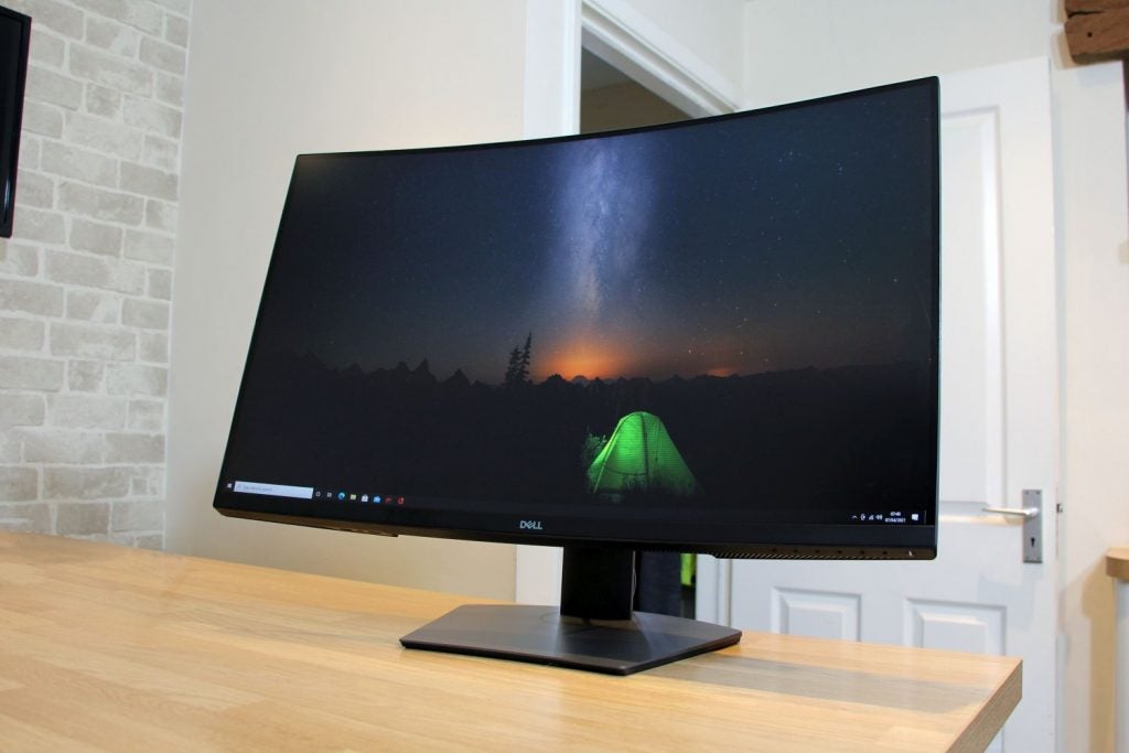 Front left view of a black Dell S3220DGF monitor displaying home screen