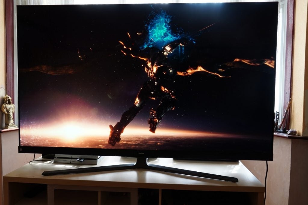 A black Hisense 65U8Q standing on a table, streaming  a scene from Pacific Rim movie