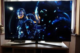 A black Hisense 65U8Q standing on a table, streaming a scene from Pacific Rim movie