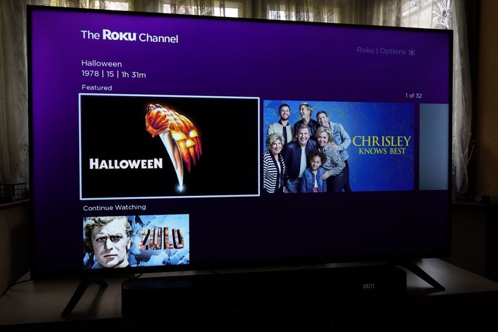 Hisense Roku R50A7200UK Roku ChannelHisense A7200G standing on table, displaying featured and continue watching content on the Roku channel