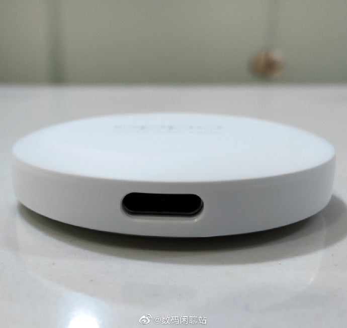 A white Oppo smart tag tracker with a charging port at the front, resting on a white background