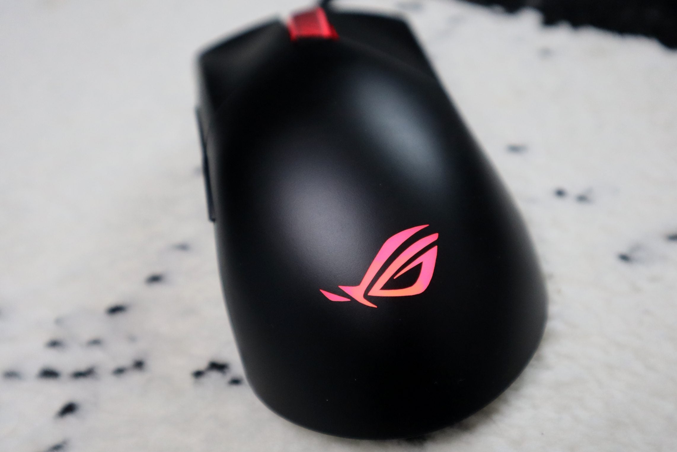 The Asus ROG logo shown on the mouse, glowing thanks to RGB lighting