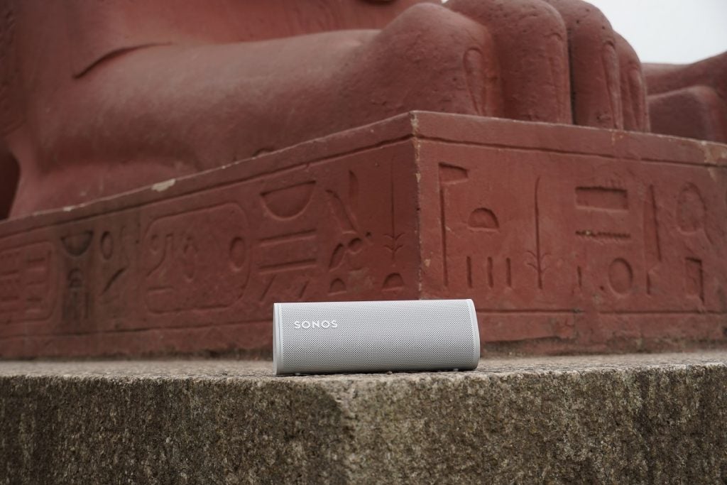 A white Sonos Roam speaker laid on a small flat pillar