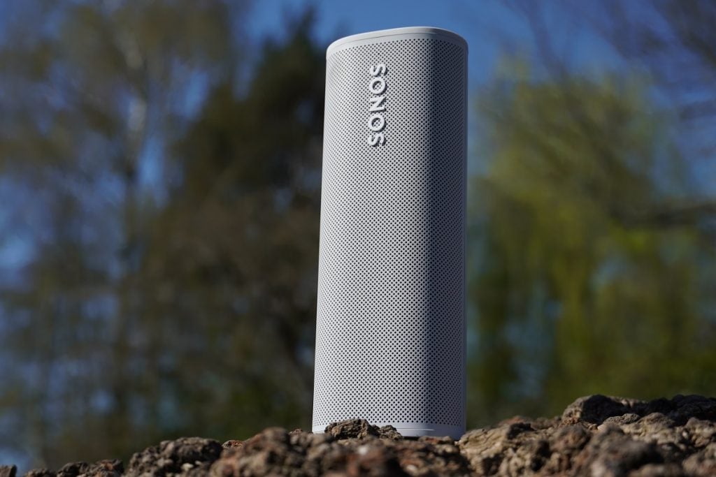 A white Sonos Roam speaker standing on ground