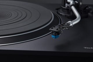 Close up image of a silver and black Technics SL 100C turntable