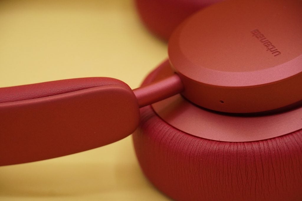 Close up image of the handle joining earpad of Urbanista Miami red headphones