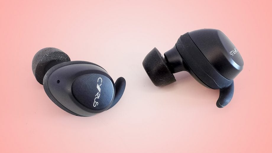 Black Cyrus 3 earbud's front and back view resting on a pale reddish pink background