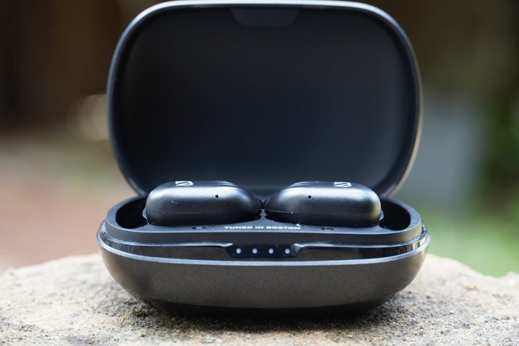 Black Bay's runner 60 wireless earbud's black case resting on ground, front top view, lid open and earbuds resting in case can be seenBlack Bay's runner 60 wireless earbud's black case resting on ground, front top view, Black bay printed in white on top