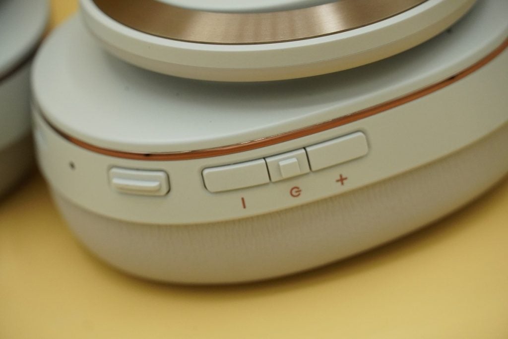 Close up image of control buttons on earcup of Cleer Enduro ANC heaphones, a power button and volume up/down buttons