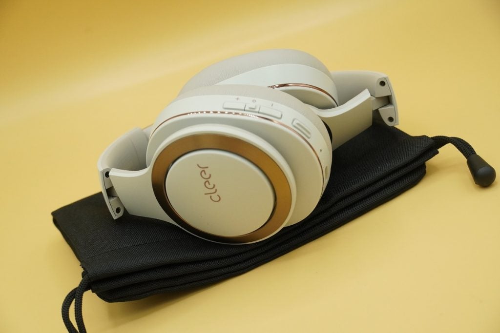 White and golden finish Cleer Enduro ANC headphones resting on black cloth case 