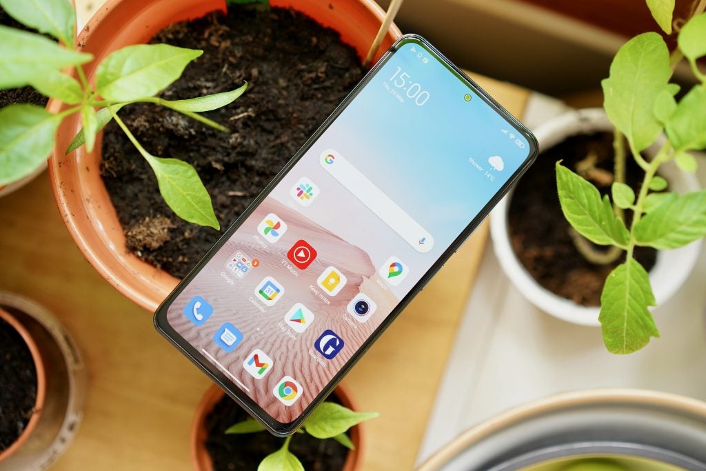 Xiaomi Mi 11i sitting on plant pots with the screen on