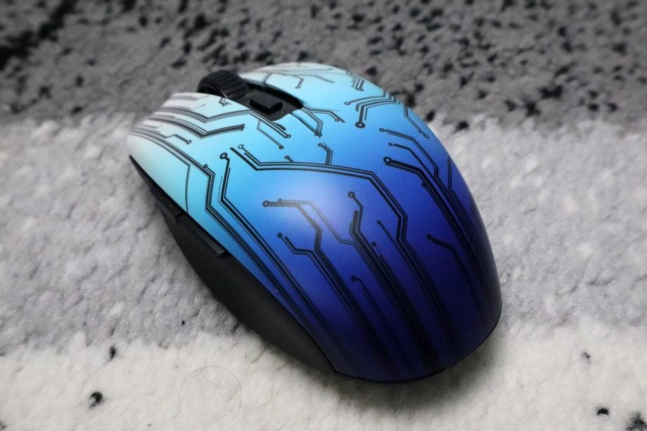 An Orchi V2 black, blue and white mouse with circuit lines on top, back left view